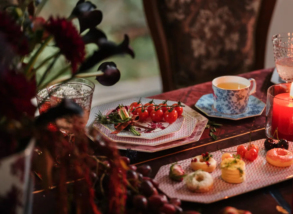 Mum ışığında Regency Damask tabakları, fincanı ve ikramlarla hazırlanmış sofra.